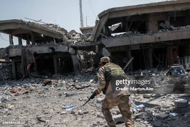 An Iraqi Army soldier runs through Islamic State sniper fire as his division advances June 17, 2017 in al-Shifa, the last district of west Mosul...