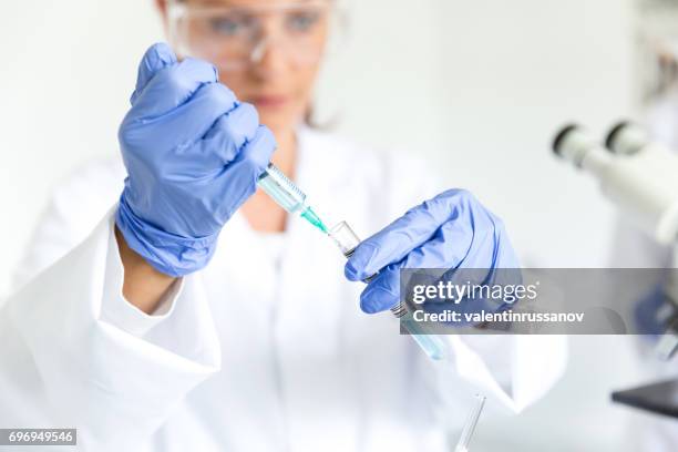 young woman making tests in laboratory - dropper bottle stock pictures, royalty-free photos & images