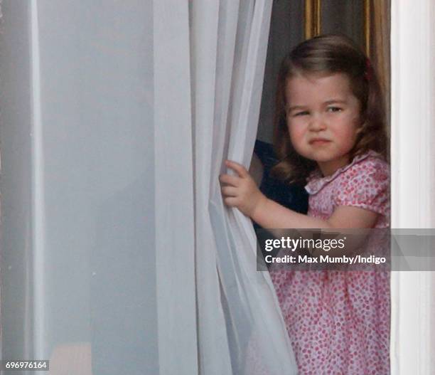 Princess Charlotte of Cambridge watches from a window of Buckingham Palace during the annual Trooping the Colour Parade on June 17, 2017 in London,...