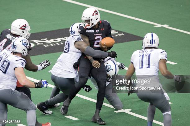 Cleveland Gladiators QB Arvell Nelson fumbles as he is hit by Baltimore Brigade OL/DL Khreem Smith and Baltimore Brigade LB Dexter Davis during the...