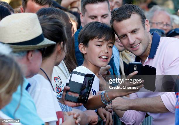 French President Emmanuel Macron, shakes hands as he leaves his home the eve of the second round of the French parliamentary elections on June 17,...