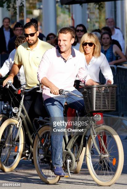 French President Emmanuel Macron with his wife Brigitte Trogneux and with his deputy chief of staff Alexandre Benalla leave their house on a bicycle...