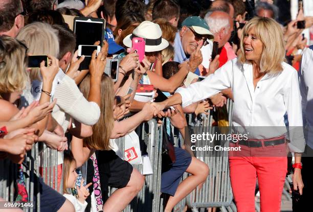 Wife of French President Emmanuel Macron, Brigitte Trogneux shakes hands as she leaves her home the eve of the second round of the French...