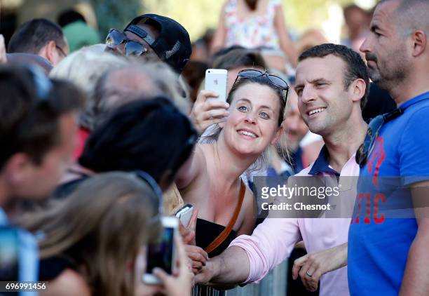 French President Emmanuel Macron, shakes hands as he leaves his home the eve of the second round of the French parliamentary elections on June 17,...
