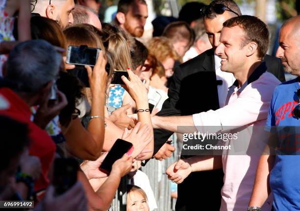 French President Emmanuel Macron, shakes hands as he leaves his home the eve of the second round of the French parliamentary elections on June 17,...