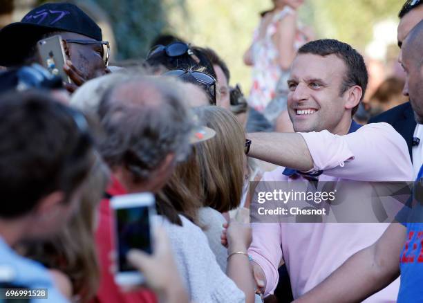 French President Emmanuel Macron, shakes hands as he leaves his home the eve of the second round of the French parliamentary elections on June 17,...