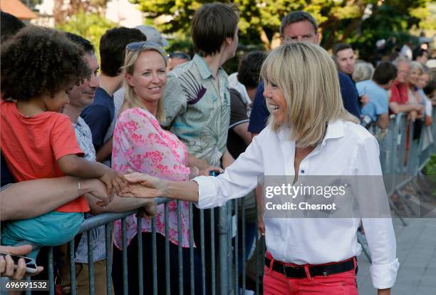 Wife of French President Emmanuel Macron, Brigitte Trogneux shakes hands as she leaves her home the eve of the second round of the French...