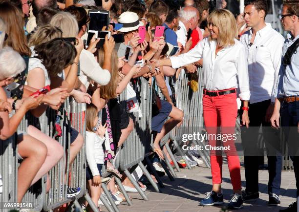 Wife of French President Emmanuel Macron, Brigitte Trogneux shakes hands as she leaves her home the eve of the second round of the French...