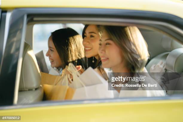 jóvenes, sentado en un taxi con bolsas - yellow taxi fotografías e imágenes de stock