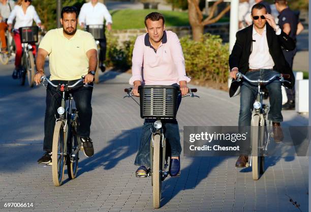 French President Emmanuel Macron returns to his house on a bicycle with his deputy chief of staff Alexandre Benalla on the eve of the second round of...