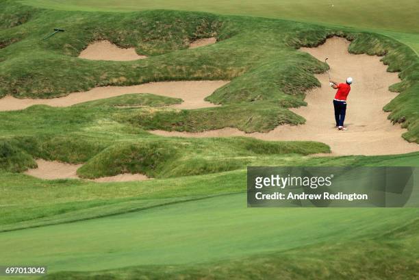 Patrick Reed of the United States plays his shot from a bunker on the 18th hole during the third round of the 2017 U.S. Open at Erin Hills on June...