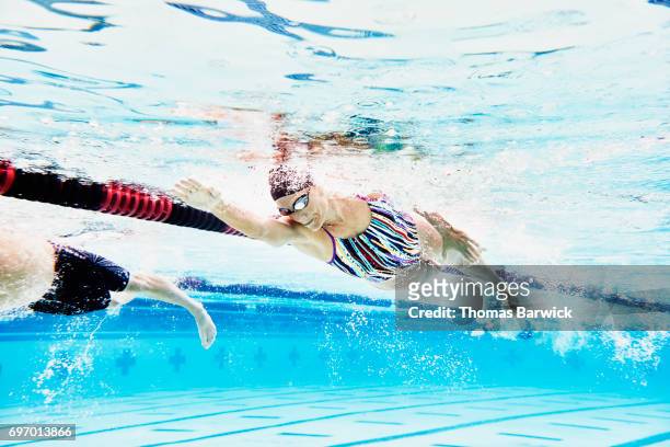 underwater view of mature female athlete swimming during workout - female swimmer bildbanksfoton och bilder