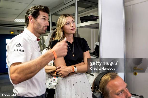 In this handout image provided by Red Bull, Former Porsche driver Mark Webber of Australia talks with professional tennis player Maria Sharapova of...