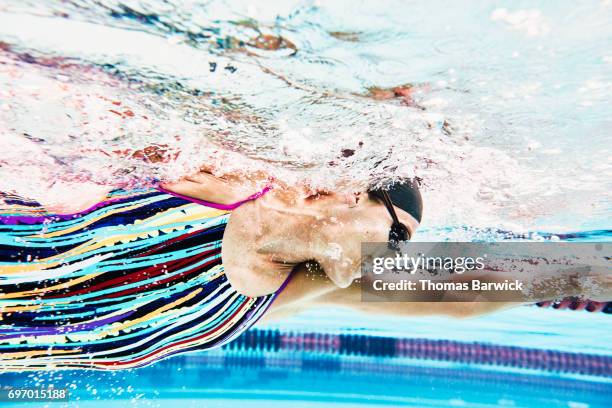 underwater view of mature female athlete swimming during workout - female swimmer bildbanksfoton och bilder