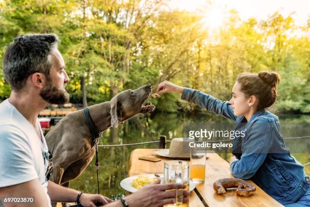 bearded father with teenage daughter and dog eating in beer garden - bar berlin stock pictures, royalty-free photos & images