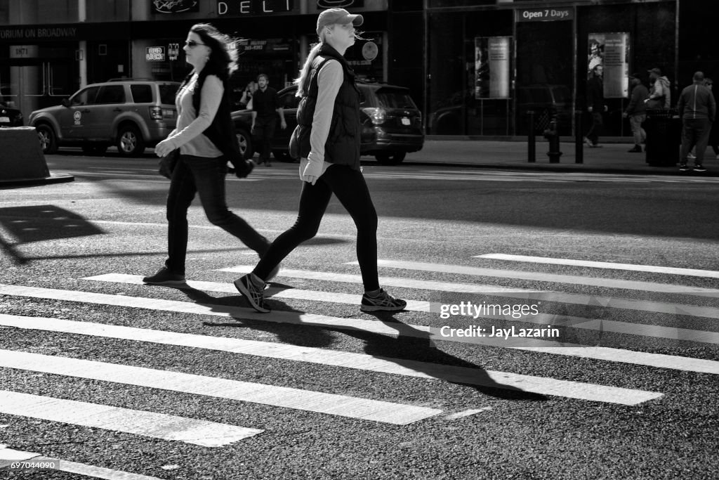 Urban Life, New York ville piétons. Deux femmes passant dans des directions opposées dans le passage pour piétons, l’Upper West Side, Manhattan