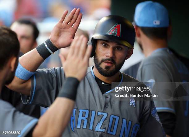 Reymond Fuentes of the Arizona Diamondbacks high fives teammates in the dugout after scoring the go ahead run in the seventh inning during a game...