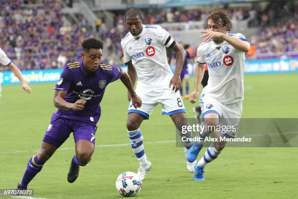 Cristian Higuita of Orlando City SC runs past Patrice Bernier of Montreal Impact and Marco Donadel of Montreal Impact during a MLS soccer match...