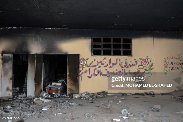 Picture taken on June 16, 2017 shows graffiti drawn by members of the Islamic State group on a wall inside the Nineveh International Hotel compound...