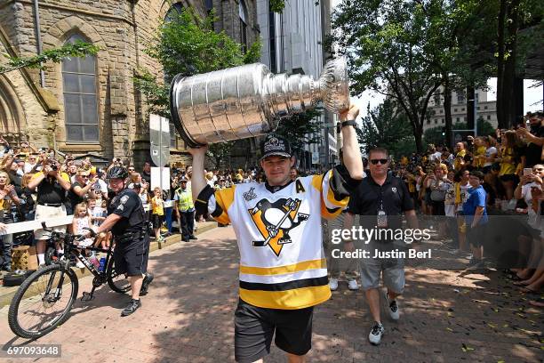 Chris Kunitz of the Pittsburgh Penguins carries the Stanley Cup during the Victory Parade and Rally on June 14, 2017 in Pittsburgh, Pennsylvania.