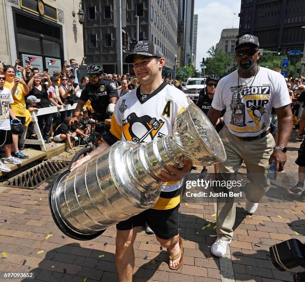 Chris Kunitz of the Pittsburgh Penguins carries the Stanley Cup during the Victory Parade and Rally on June 14, 2017 in Pittsburgh, Pennsylvania.