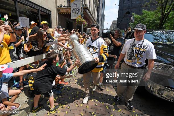 Kris Letang of the Pittsburgh Penguins walks with the Stanley Cup as fans touch it during the Victory Parade and Rally on June 14, 2017 in...