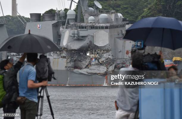 Crew films the damages on the guided missile destroyer USS Fitzgerald at its mother port in Yokosuka, southwest of Tokyo on June 18, 2017. A number...