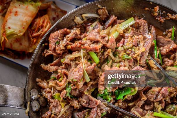 delicious grilled  bulgogi , marinated in soy sauce and garlic and ginger - iron bowl stock pictures, royalty-free photos & images