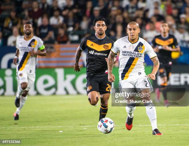 Rafael Garcia of Los Angeles Galaxy is chased by A. J. DeLaGarza of Houston Dynamo during the Los Angeles Galaxy's MLS match against Houston Dynamo...
