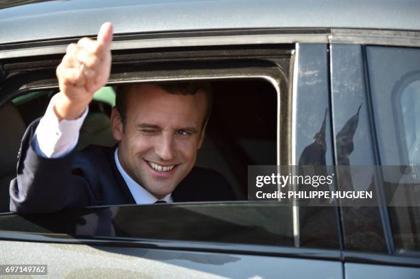 French President Emmanuel Macron gestures from his car as he leaves to vote in Le Touquet, northern France, during the second round of the French...
