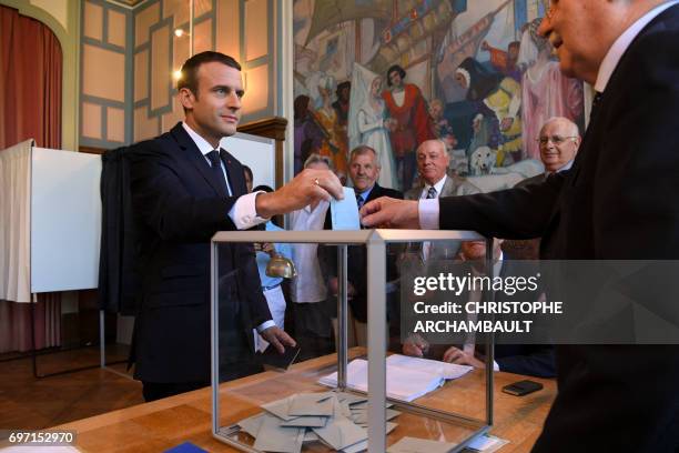 French President Emmanuel Macron casts his ballot as he votes at a polling station in Le Touquet, northern France, during the second round of the...
