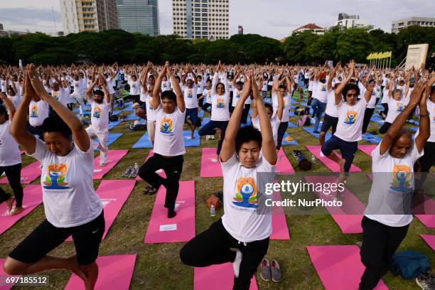 Thousands of people participate in a yoga exercise at Chulalongkorn University field, marking the International Day of Yoga in Bangkok, Thailand....