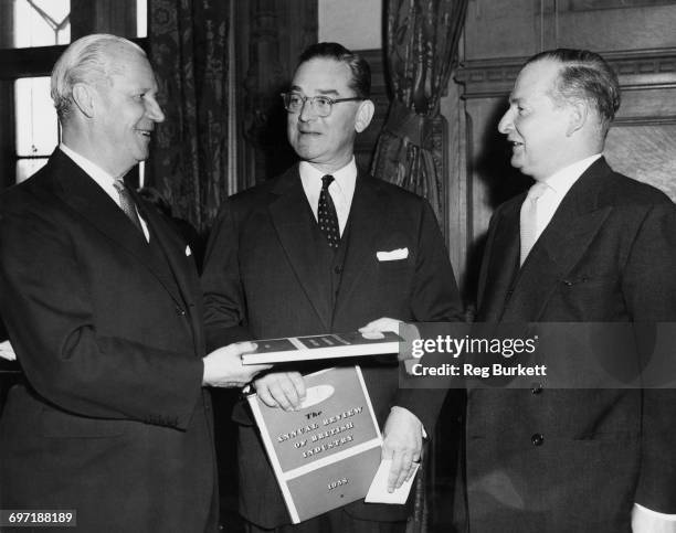 British Foreign Secretary Selwyn Lloyd presents copies of 'The Annual review of British Industry 1958' to the US and Canadian ambassadors in the...