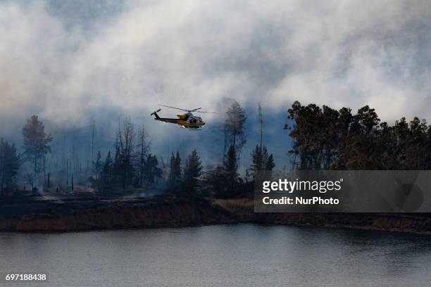 Los Angeles County Fire Department helicopter flies over Castaic Lake during a wildfire in Castaic, California on June 17, 2017. Castaic, California...