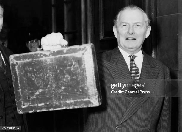 British Chancellor of the Exchequer Selwyn Lloyd holds up the red despatch box as he leaves the Treasury to present his first budget at the House of...