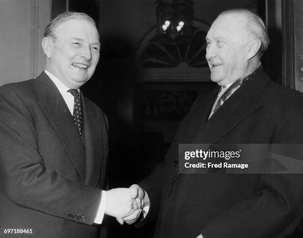 British Foreign Secretary Selwyn Lloyd shakes hands with West German Chancellor Konrad Adenauer on his arrival for lunch at at Lloyd's official...