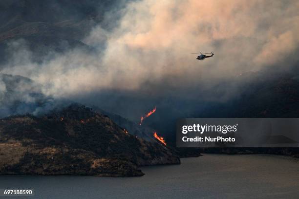 Los Angeles County Fire Department helicopter flies over Castaic Lake during a wildfire in Castaic, California on June 17, 2017. Castaic, California...