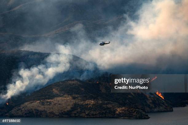 Los Angeles County Fire Department helicopter flies over Castaic Lake during a wildfire in Castaic, California on June 17, 2017. Castaic, California...