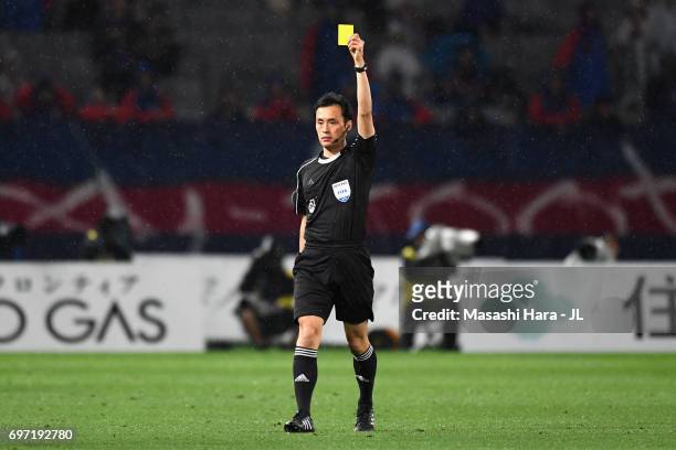 Referee Hiroyuki Kimura shows an yellow card to Kosuke Ota of FC Tokyo during the J.League J1 match between FC Tokyo and Yokohama F.Marinos at...