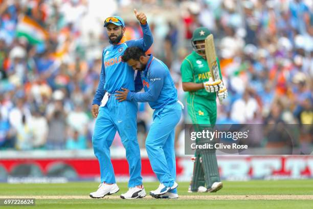 Kedar Jadhav of India celebrates the wicket of Babar Azam of Pakistan with Virat Kohli during the ICC Champions trophy cricket match between India...