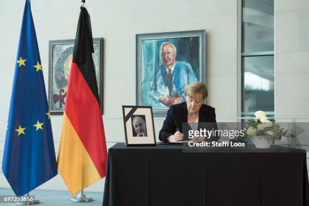 German Chancellor Angela Merkel writes in a book of condolence for former German Chancellor Helmut Kohl in front of the Chancellor's gallery at the...