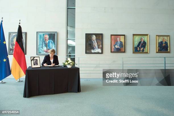 German Chancellor Angela Merkel writes in a book of condolence for former German Chancellor Helmut Kohl in front of the Chancellor's gallery at the...