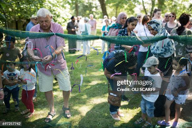 Gordon Leadbeater , the father of murdered Member of Parliament Jo Cox, joins others in tying a ribbon onto a piece of netting during a 'Great Get...