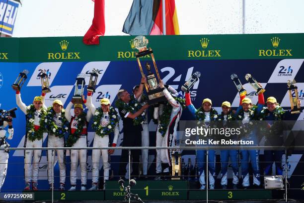 The overall winning The Porsche LMP Team 919 of Earl Bamber, Timo Bernhard and Brendon Hartley celebrate on the podium following the Le Mans 24 Hours...