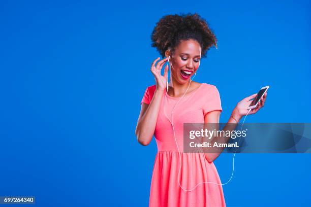 fête tous les temps - fashion pretty woman listening music in headphones with smartphone colorful photos et images de collection