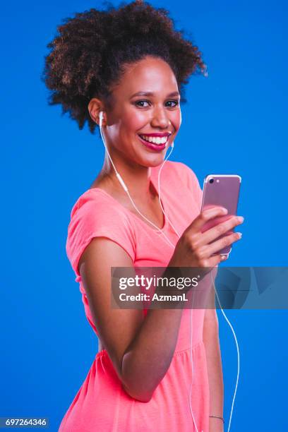 la musique est ma passion - fashion pretty woman listening music in headphones with smartphone colorful photos et images de collection