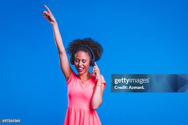 i 'm going to de hele nacht lang party - fashion pretty woman listening music in headphones with smartphone colorful stockfoto's en -beelden