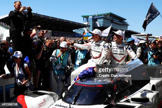 Timo Bernhard drives the winning Porsche LMP Team 919 down the pitlane with his co-drivers Brendon Hartley and Earl Bamber on top after victory in...