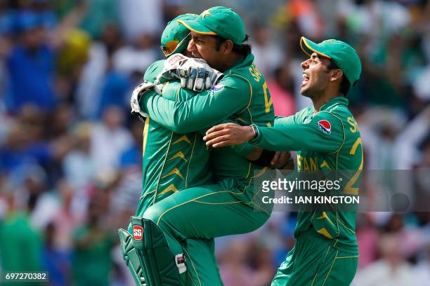 Pakistan's Shadab Khan and Pakistan's Sarfraz Ahmed celebrate with Pakistan's Imad Wasim after he catches India's MS Dhoni during the ICC Champions...