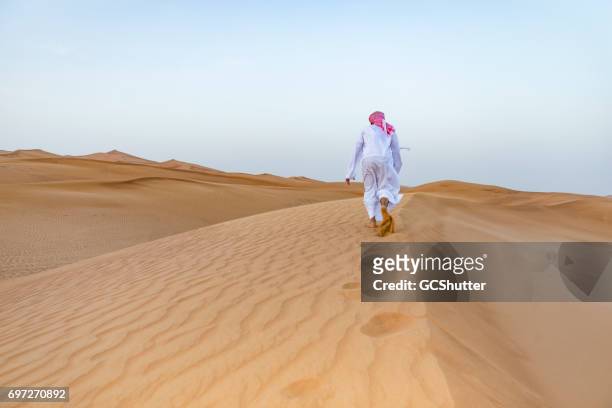 arabes marcher sur les dunes - foulard vent photos et images de collection